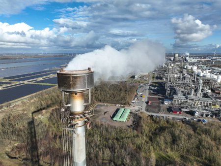Rauchschwaden in einer großen Raffinerie in Moerdijk, Niederlande. Rauchender Schornstein. Chemische Verarbeitung. Fossile Produkte und Kunststoffe.