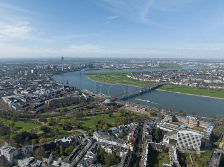 Drohnenaufnahme aus der Luft über der Skyline von Düsseldorf. Stadtsilhouette, Fernsehturm, Rheinknie-Brücke, Rhein und städtische Infrastruktur.