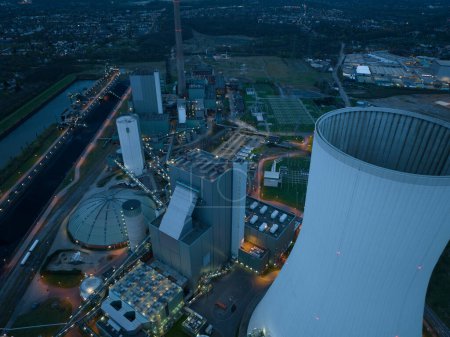 Vue aérienne du drone sur la centrale électrique de Duisburg Walsum la nuit. Une centrale thermique alimentée au charbon génère également de la chaleur pour le chauffage urbain et une cheminée de 300 m de haut. Infrastructures énergétiques en Allemagne