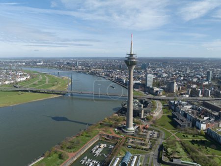 Drohnenaufnahme aus der Luft über der Skyline von Düsseldorf. Stadtsilhouette, Fernsehturm, Rheinknie-Brücke, Rhein und städtische Infrastruktur.