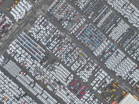 Aerial drone views of transportation of vehicles over seas from a sea port terminal, specifically the Zeebrugge, intermodal logistics, roll on roll off cargo, and loading unloading of new vehicles.
