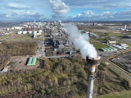Luftaufnahme einer Drohne auf einem Schornstein im Erdöl- und Chemiepark von Moerdijk, Niederlande. Rauch und industrielle Umweltverschmutzung.