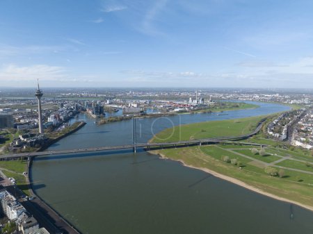 Aerial drone view over Dusseldorf, including the Rhine River and the Oberkasseler Brucke, capturing their scenic and architectural features.