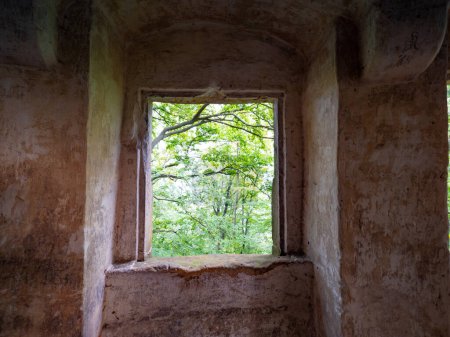 Photo for Stony House  with stony fgrame window. Abandoned stone house with empty window frame overlooks a foggy forest. - Royalty Free Image
