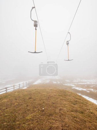 Photo for Empty t-bar lift in heavy fog in Ore mountains, Klinovec. End of season in foggy weather - Royalty Free Image