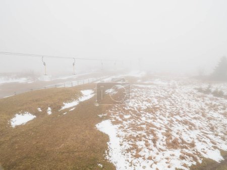 Photo for Empty t-bar lift in heavy fog in Ore mountains, Klinovec. End of season in foggy weather - Royalty Free Image