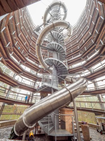 Photo for Treetop trail toer in Janske lazne town, Czech Republic. There is a spiral staircase, a steel tobogan with several twists and the lookout tower construction itself, circular wooden threads ascending to the top of the tower. - Royalty Free Image