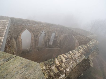 Photo for The ruins of Oybin in the mist.. The temple and burg  founded as Celestines monastery in 1369 in the Zittau Mountains on the border of Germany Saxony with the Czech Republic - Royalty Free Image