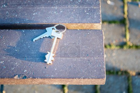 Téléchargez les photos : Les clés perdues de la maison reposent sur un banc en bois. clés oubliées se trouvent le bench.You ne rentrera pas à la maison si vous perdez vos keys.Selective focus. - en image libre de droit