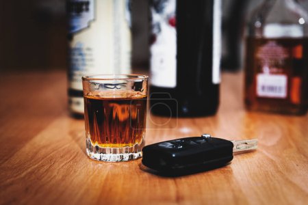 ein Glas Whiskey und Autoschlüssel auf dem Tisch. Betrunken fahren. Trinken und Autoschlüssel. Autofahren oder nicht fahren, Alkoholabhängigkeitskonzept.