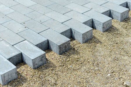 Photo for Pavement repairs and paving slabs laying on the prepared surface, with tile cubes in the background.Paving slabs and curbs,closeup. Laying paving slabs in the pedestrian zone of the city.Closeup. - Royalty Free Image