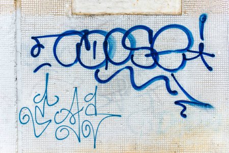 Photo for Fragment of graffiti drawings.Old wall decorated with paint stains in the style of street art culture. Colored background texture in cold tones.Vilnius,Lithuania.07-21-2023. - Royalty Free Image