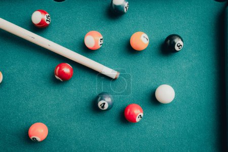 Photo for Sports game of billiards on a green cloth.Multi colored billiard balls in the form of a triangle with numbers,a cue ball and a triangle on a pool table. billiard balls closeup.Toned. - Royalty Free Image