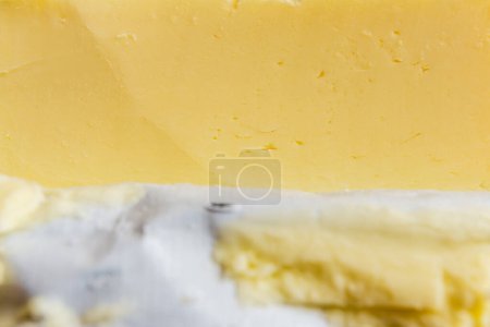 Sliced butter in maker's paper, macro shot, closeup.