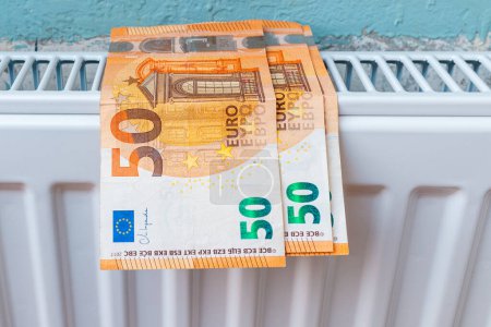 Heat price growth. Expensive heating. Heating radiator at home on it euro current money.