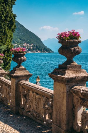 Schöne alte Skulptur mit Blumensäulen im botanischen Garten der berühmten mediterranen Villa Monastero, gelegen im traditionellen Dorf Varenna, Provinz Lecco, am Ufer des Comer Sees, Italien.