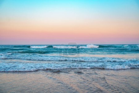 Photo for Spectacular panorama of the Coral Sea and crushing surfing waves against the pristine beach during beautiful sunrise. - Royalty Free Image