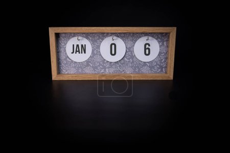 Photo for A wooden calendar block showing the date January 6th on a dark black background - Royalty Free Image