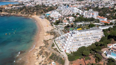 Photo for Aerial photo of the beautiful town in Albufeira in Portugal showing the Praia da Oura golden sandy beach, with hotels and apartment in the town, taken on a summers day in the summer time. - Royalty Free Image