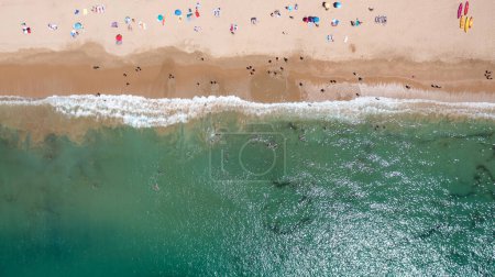Foto de Foto aérea recta de la hermosa ciudad de Albufeira en Portugal que muestra la playa de Praia da Oura con y la gente que se relaja de vacaciones en la playa en un día caluroso de verano en la hora de verano. - Imagen libre de derechos