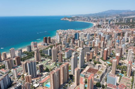 Aerial drone photo of the beautiful city of Benidorm in Spain in the summer time showing high rise apartments hotels and the main roads in the city in the summer time