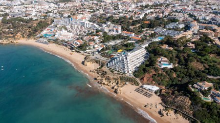Foto de Foto aérea de la hermosa ciudad de Albufeira en Portugal que muestra la playa de arena dorada Praia da Oura, con hoteles y apartamentos en la ciudad, tomada en un día de verano en la hora de verano. - Imagen libre de derechos