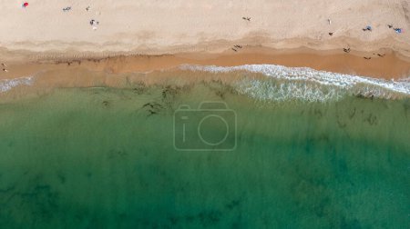 Foto de Foto aérea recta de la hermosa ciudad de Albufeira en Portugal que muestra la playa de Praia da Oura con y la gente que se relaja de vacaciones en la playa en un día caluroso de verano en la hora de verano. - Imagen libre de derechos