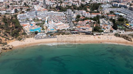 Foto de Foto aérea de la hermosa ciudad de Albufeira en Portugal que muestra la playa de arena dorada Praia da Oura, con hoteles y apartamentos en la ciudad, tomada en un día de verano en la hora de verano. - Imagen libre de derechos