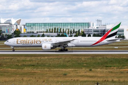 Photo for Munich / Germany - July 11, 2017: Emirates Airlines Boeing 777-300ER A6-ECV passenger plane departure and take off at Munich Airport - Royalty Free Image