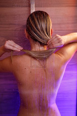 Téléchargez les photos : Une blonde spectaculaire prend soin de ses cheveux sous la douche - en image libre de droit