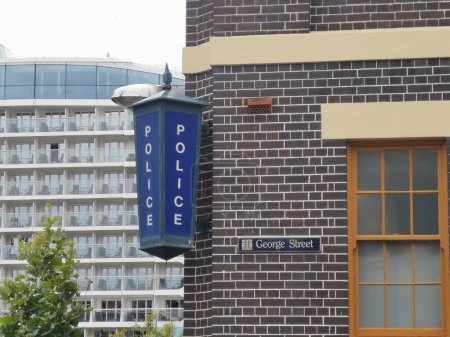 Téléchargez les photos : 7 décembre 2022 Sydney, Australie : Extérieur du poste de police de Sydney montrant un panneau de police bleu et un panneau routier George Street avec un bâtiment moderne en arrière-plan. Photo de haute qualité - en image libre de droit