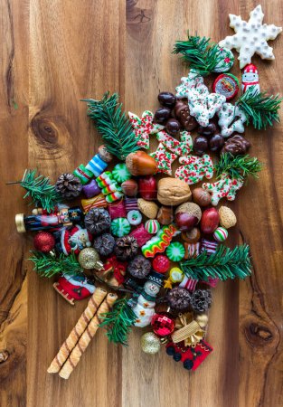 Téléchargez les photos : Diverses confiseries festives et ornements en forme d'arbre sur une planche de bois. - en image libre de droit