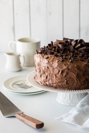 Photo for A large homemade low sugar low carb chocolate cake on a pedestal stand, ready for serving. - Royalty Free Image