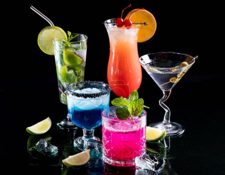 Téléchargez les photos : Cocktails colorés brillants réfléchissant sur verre, sur un fond noir. - en image libre de droit