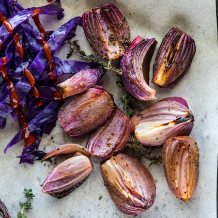 Téléchargez les photos : Vue du haut vers le bas des oignons rouges rôtis au thym, le long du côté cuit à la vapeur chou violet. - en image libre de droit