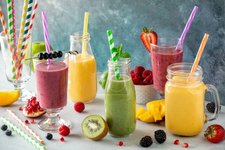 Refreshing bright and colourful fruit smoothies with colourful straws, ready for drinking. 