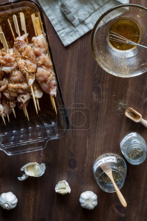 Photo for Above view of marinating raw chicken skewers surrounded by ingredients for marinating. - Royalty Free Image