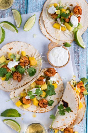 Photo for Top down view of homemade spicy shrimp tacos with lime and cilantro, ready for eating. - Royalty Free Image