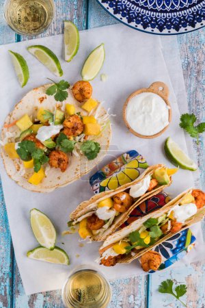 Photo for A top down view of homemade spicy shrimp tacos with lime yogurt sauce and garnished with cilantro. - Royalty Free Image