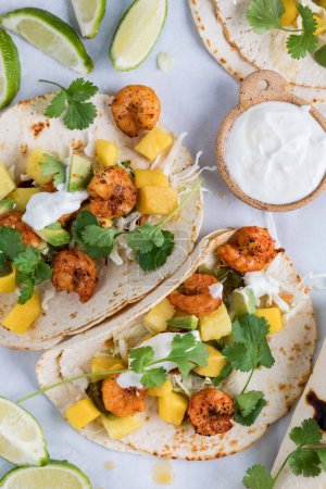 Photo for Homemade spicy shrimp tacos with a tropical salsa and lime flavoured yogurt sauce. - Royalty Free Image