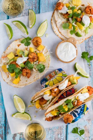 Photo for Delicious spicy shrimp tacos with a tropical salsa and lime yogurt sauce. - Royalty Free Image