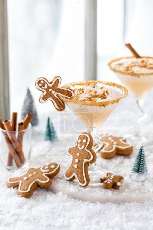 Téléchargez les photos : Gingerbread martini cocktails avec du pain d'épice hommes biscuits contre une fenêtre lumineuse. - en image libre de droit