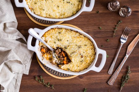 Photo for Individual casserole dishes of homemade cottage pie topped with mashed cauliflower, ready for eating. - Royalty Free Image