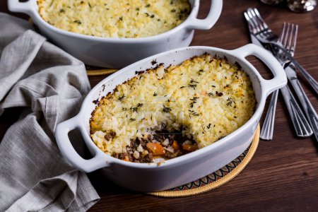 Photo for Casserole dishes of homemade cauliflower Cottage Pie, with a slice out of the front one. - Royalty Free Image