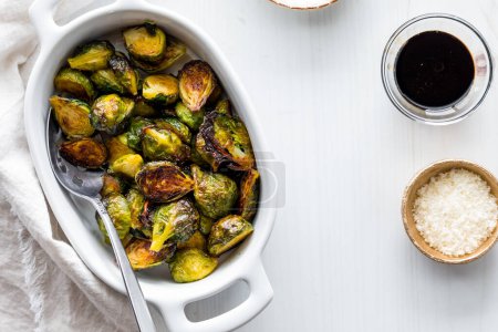 Photo for A dish of roasted brussels sprouts with balsamic reduction and parmesan cheese. - Royalty Free Image