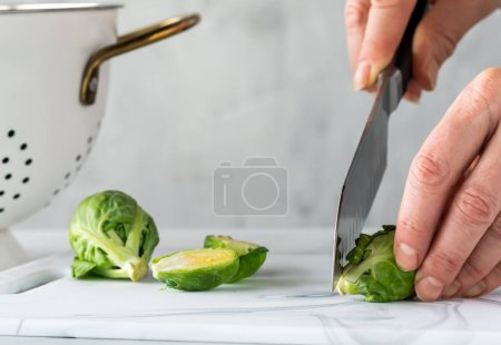 Photo for A close up of hands preparing fresh brussels sprouts for cooking. - Royalty Free Image