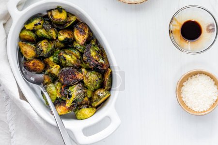 Photo for Roasted brussel sprouts topped with balsamic vinegar and served with parmesan cheese. - Royalty Free Image