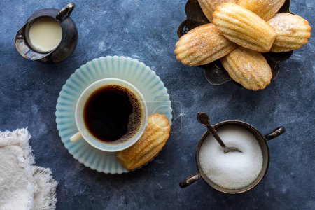 Blick auf eine Tasse Kaffee, serviert mit traditionellen französischen Madeleines. 