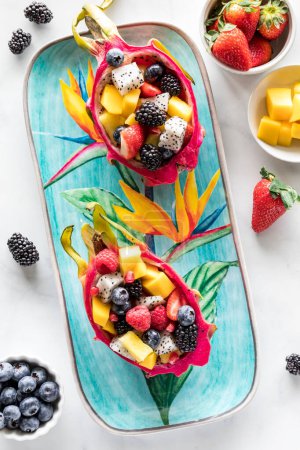 Above view of fresh Dragon Fruit salad bowls on a colourful tropical platter. 