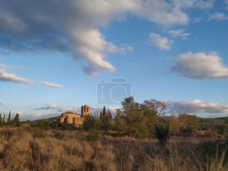 Foto de Paisaje con iglesia bajo un cielo azul con algunas nubes. - Imagen libre de derechos